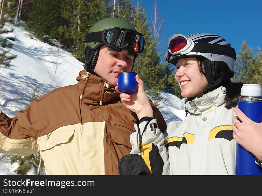 Couple of snowboarders drinking hot tee