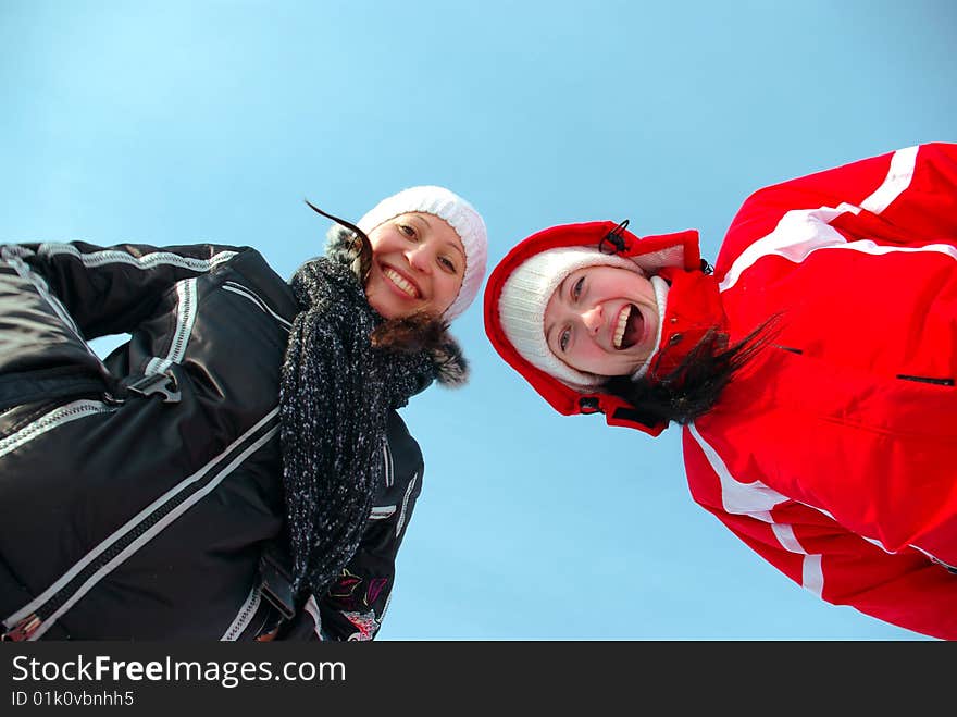 Two happy young gilrs on the blue background. Two happy young gilrs on the blue background