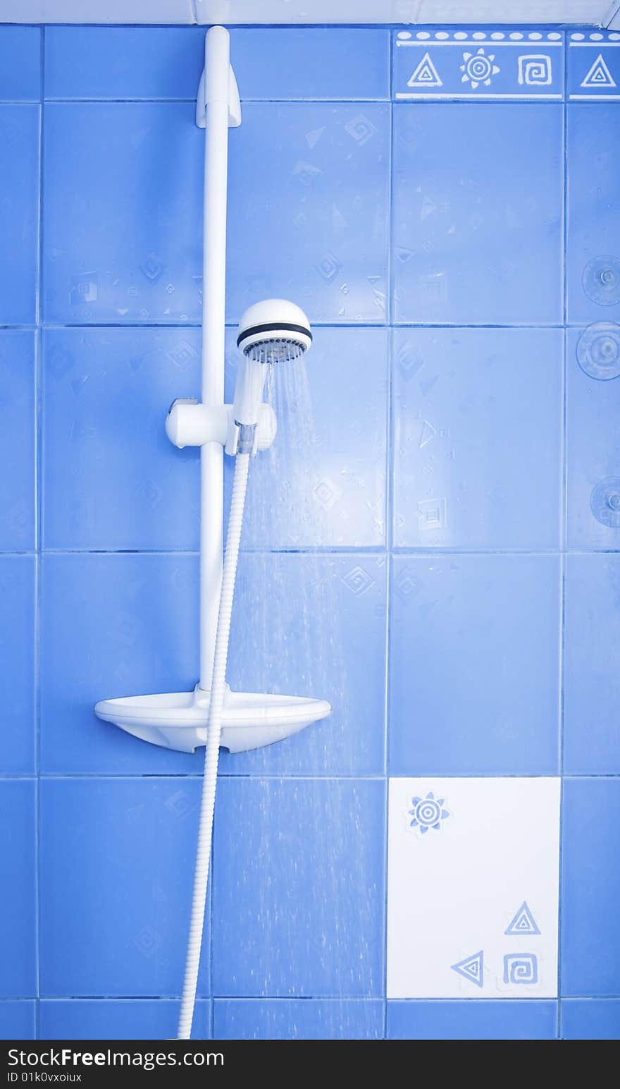 White shower and drops of water on blue tiling background. White shower and drops of water on blue tiling background