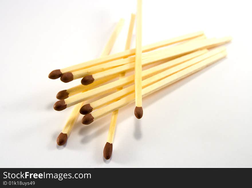 Pile of matches with brown tips on a white background