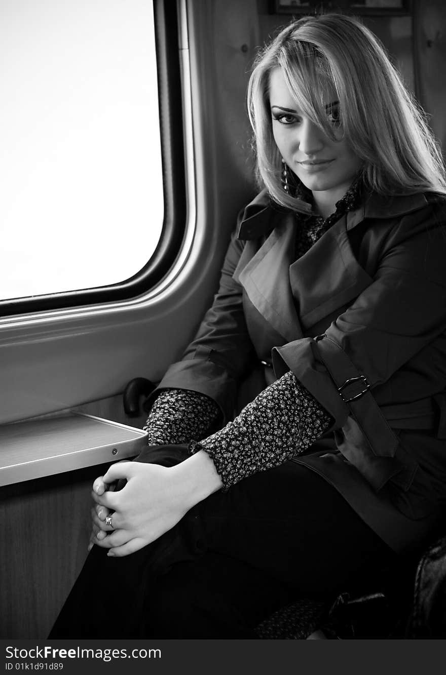 Beautiful girl sitting near a window in the passenger car