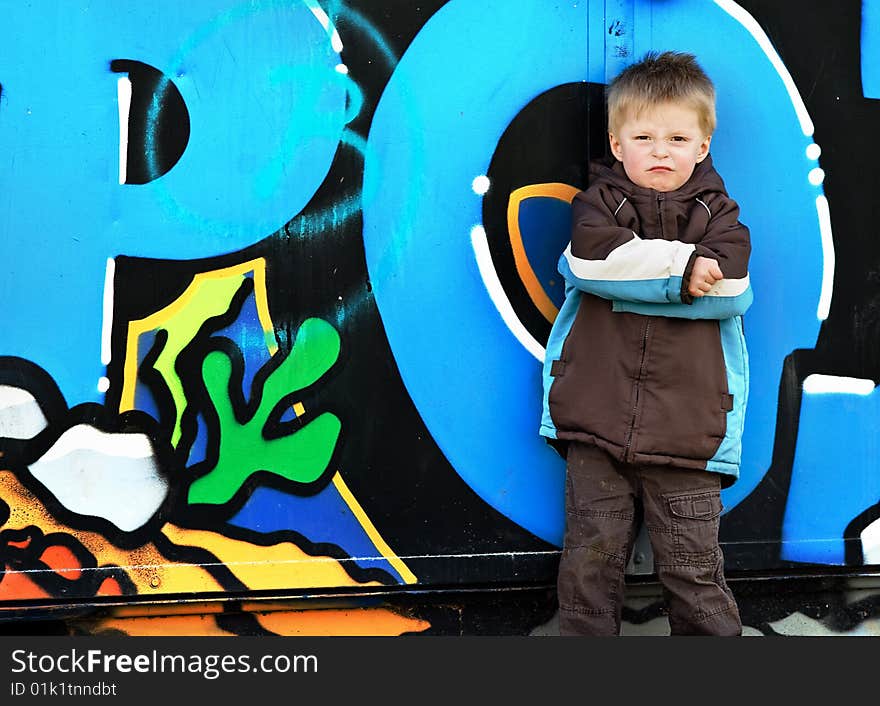 Boy against graffiti wall.