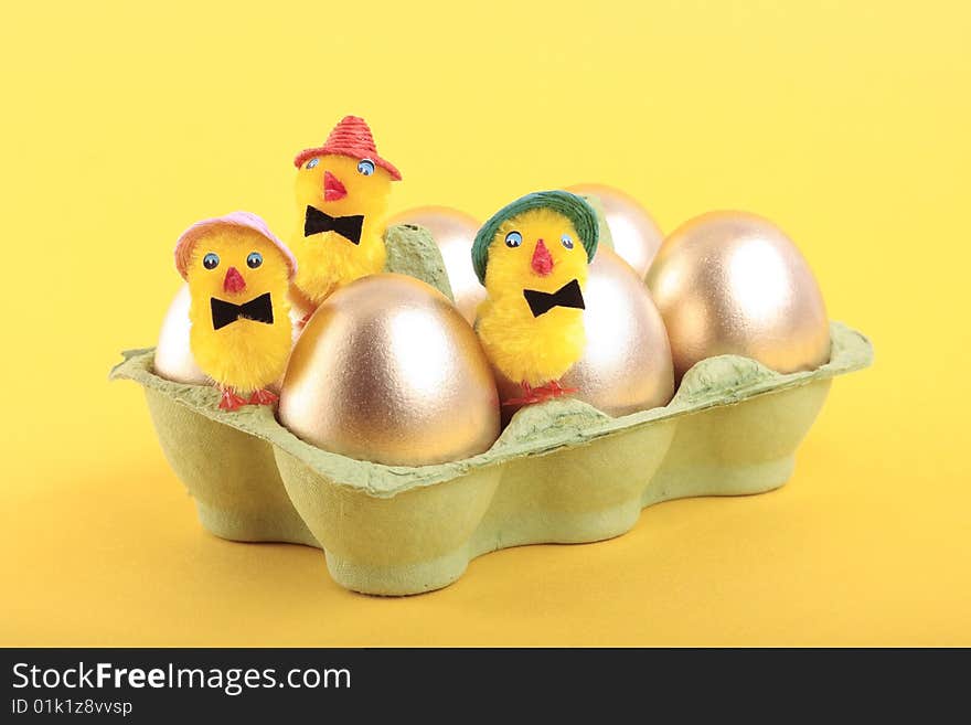 Golden Easter eggs and chicks in carton