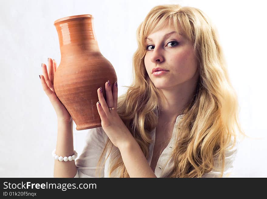 Portrait of a young blonde girl with jug in the white background