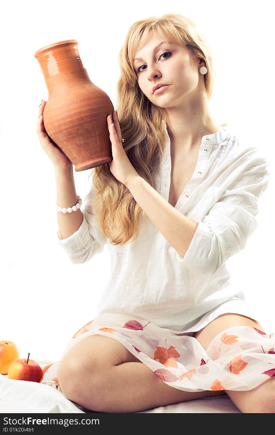 Portrait of a young blonde girl with jug in the white background