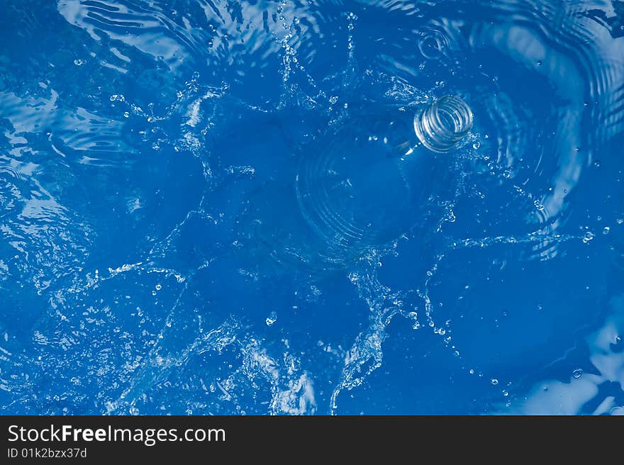 Bottle with splashing water.Blue Background