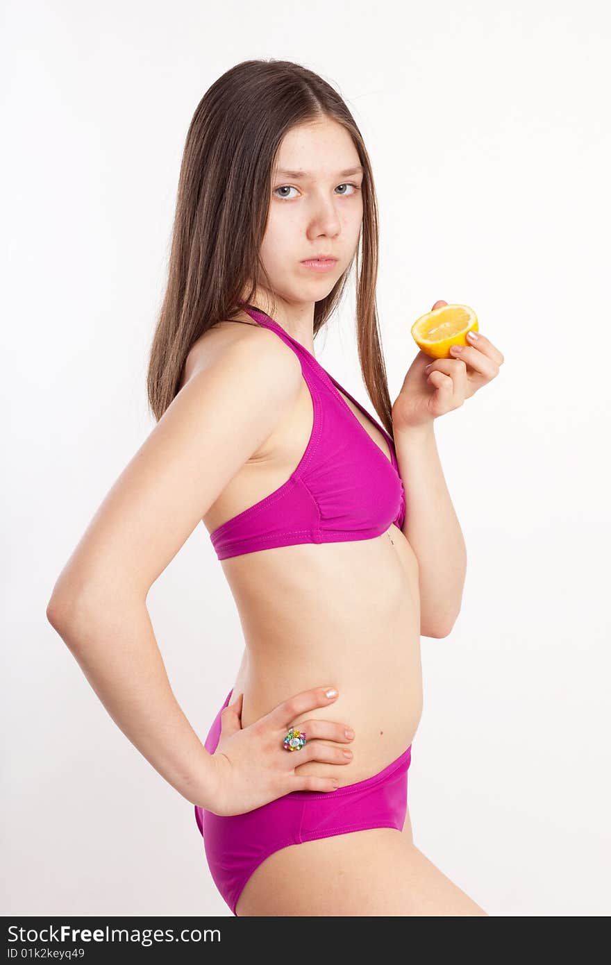 Long hair teen in bikini with piece of lemon. Long hair teen in bikini with piece of lemon