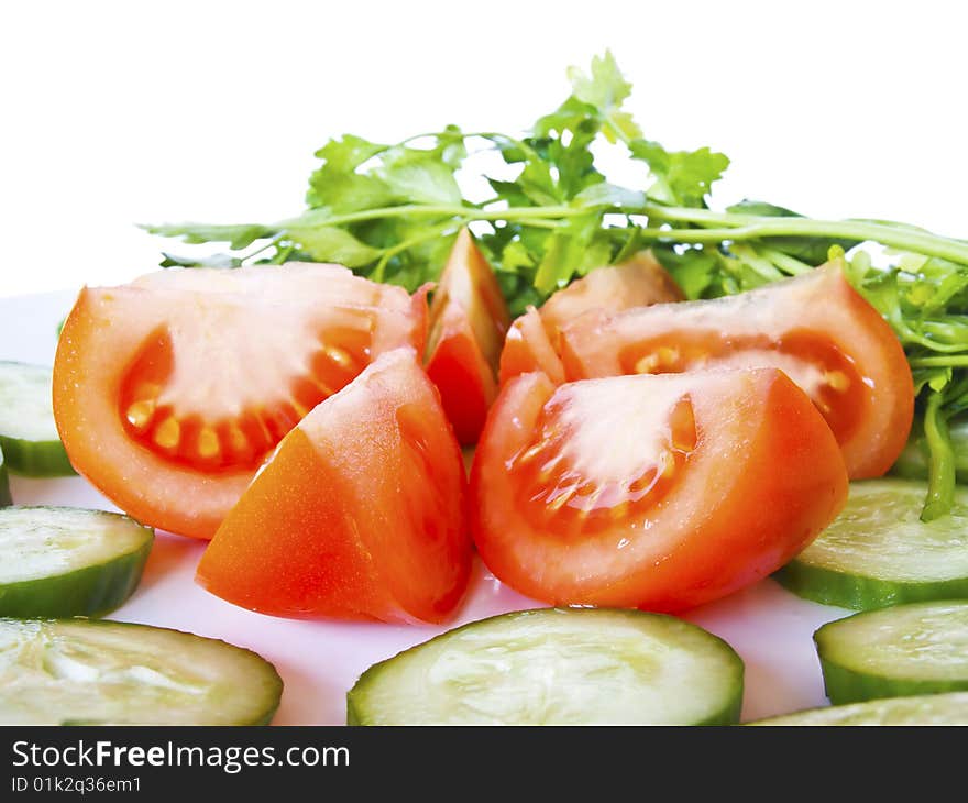 Tomatoes and cucumber on the plate with white background. Tomatoes and cucumber on the plate with white background