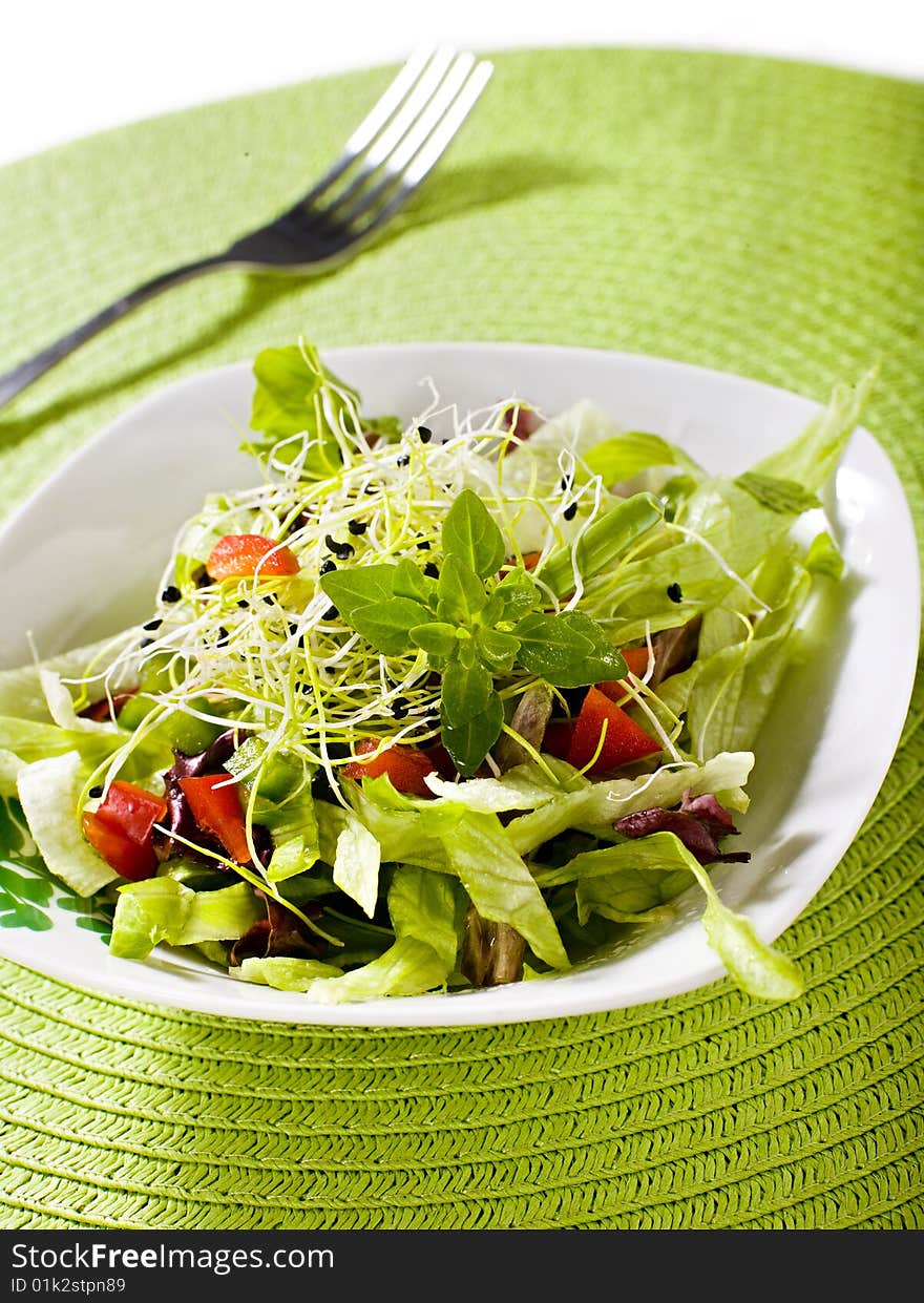 Fresh salad with fork and green cover