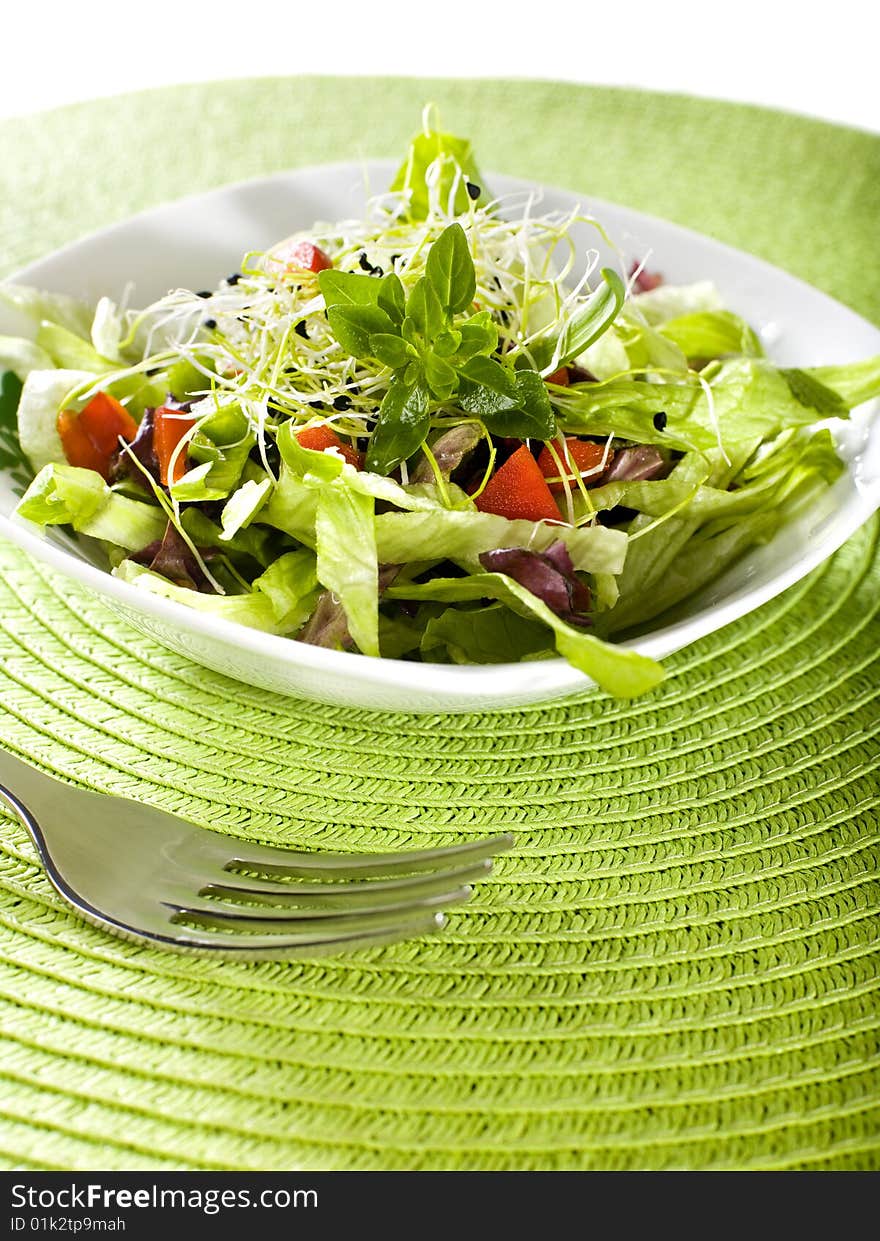 Fresh salad with fork and green cover