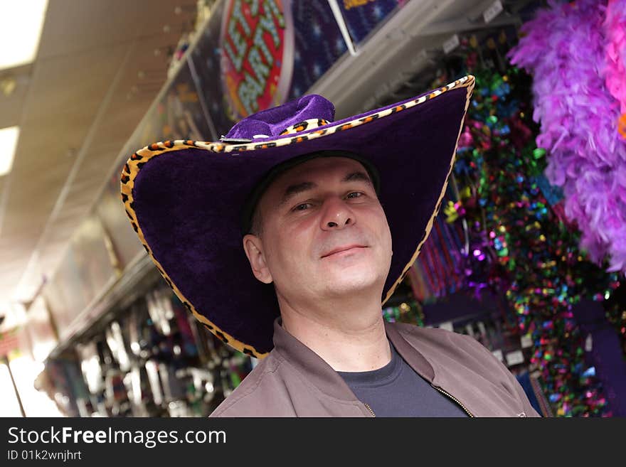 The man poses in a fun hat. The man poses in a fun hat