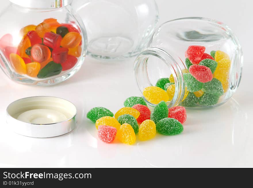 Fruit jellys in glass phial on white background