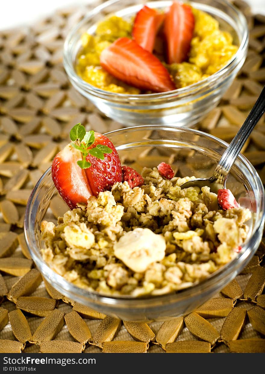 Cornflakes and musli with strawberry on a wooden cover