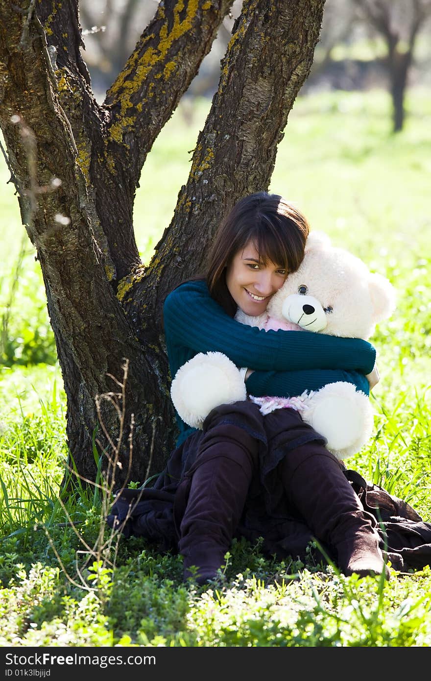 Young smiling woman embracing a teddy bear. Young smiling woman embracing a teddy bear