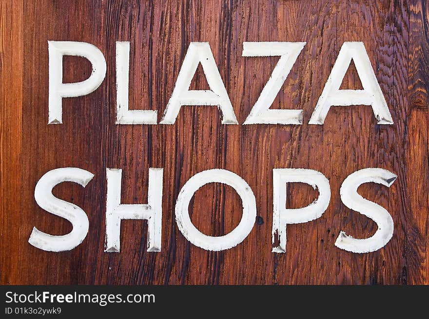 Old dark wooden Plaza Shops sign