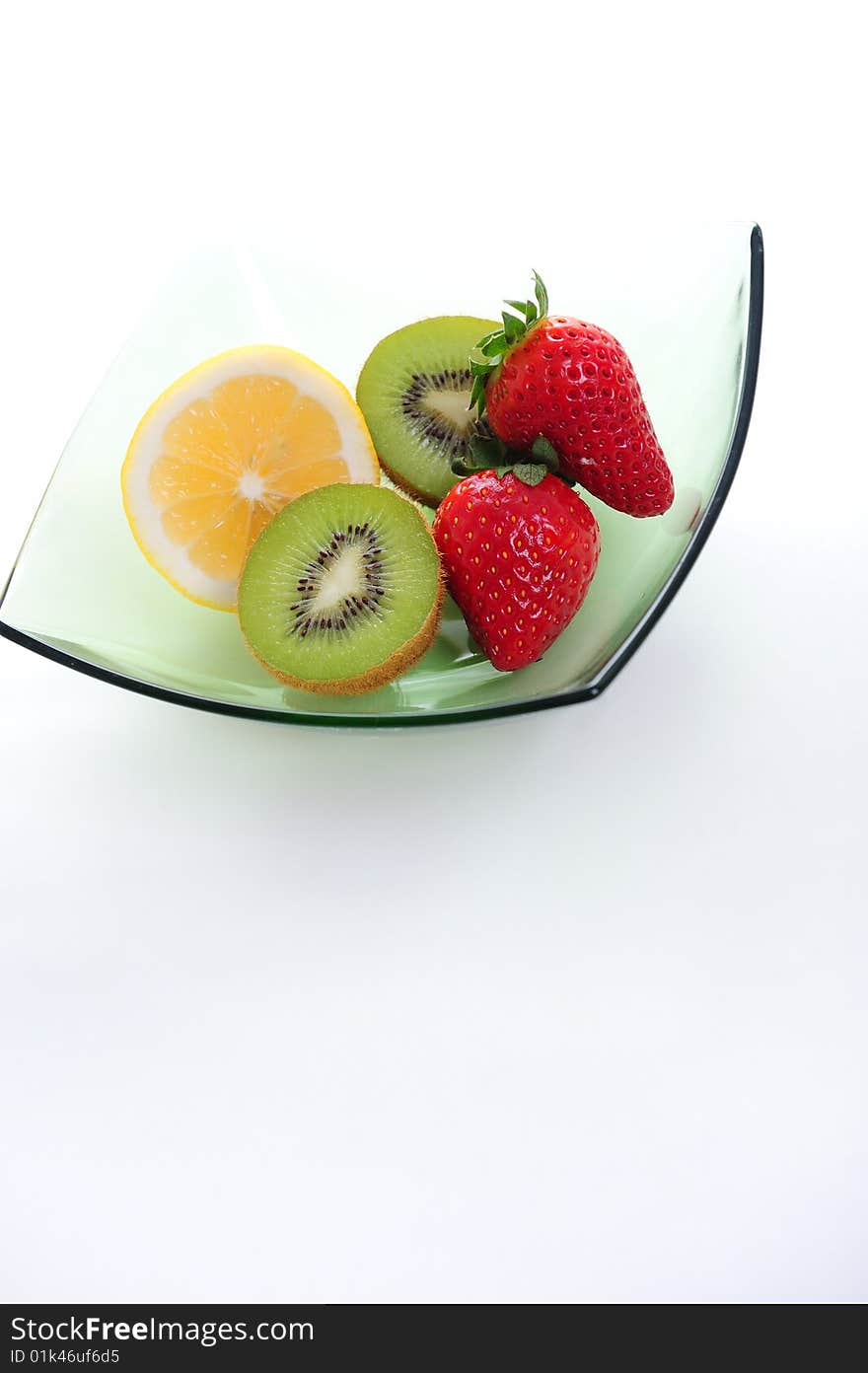 Kiwi, strawberry and lime on green bowl. Kiwi, strawberry and lime on green bowl