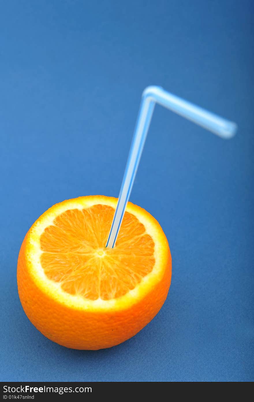 Fresh orange fruit with straw, on blue background. Fresh orange fruit with straw, on blue background