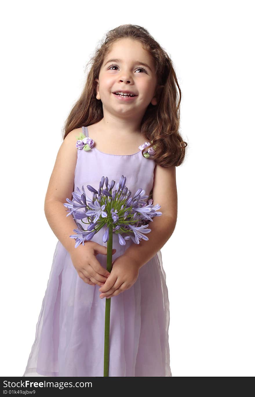 Smiling girl looking up holding a purple agapanthus flower.  Space for your copy. Smiling girl looking up holding a purple agapanthus flower.  Space for your copy.