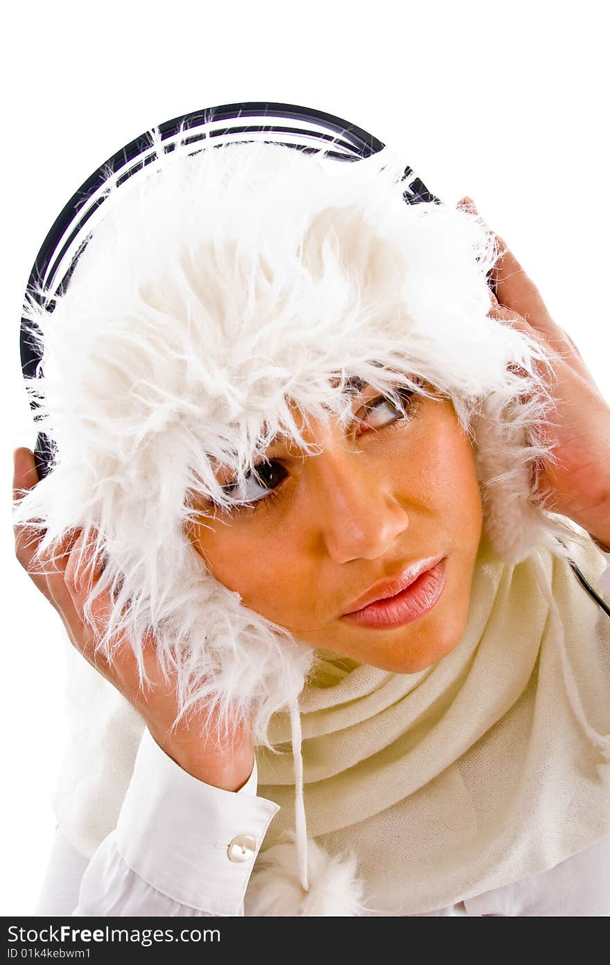 Woman holding headphone and looking upward against white background