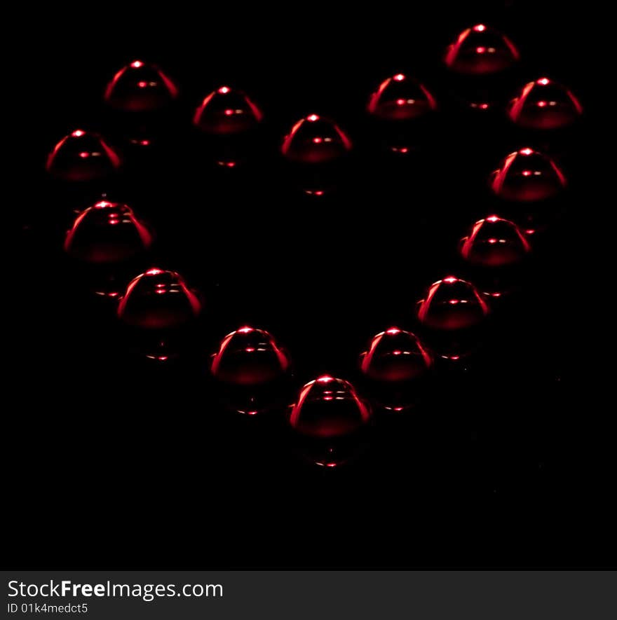 Water drops in the form of heart on a celebratory background