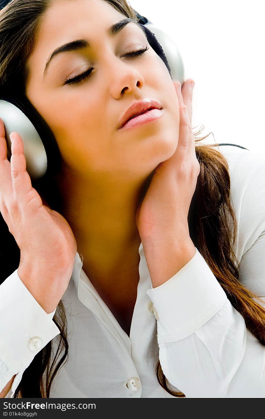 Young girl listening light music with closed eyes on an isolated background