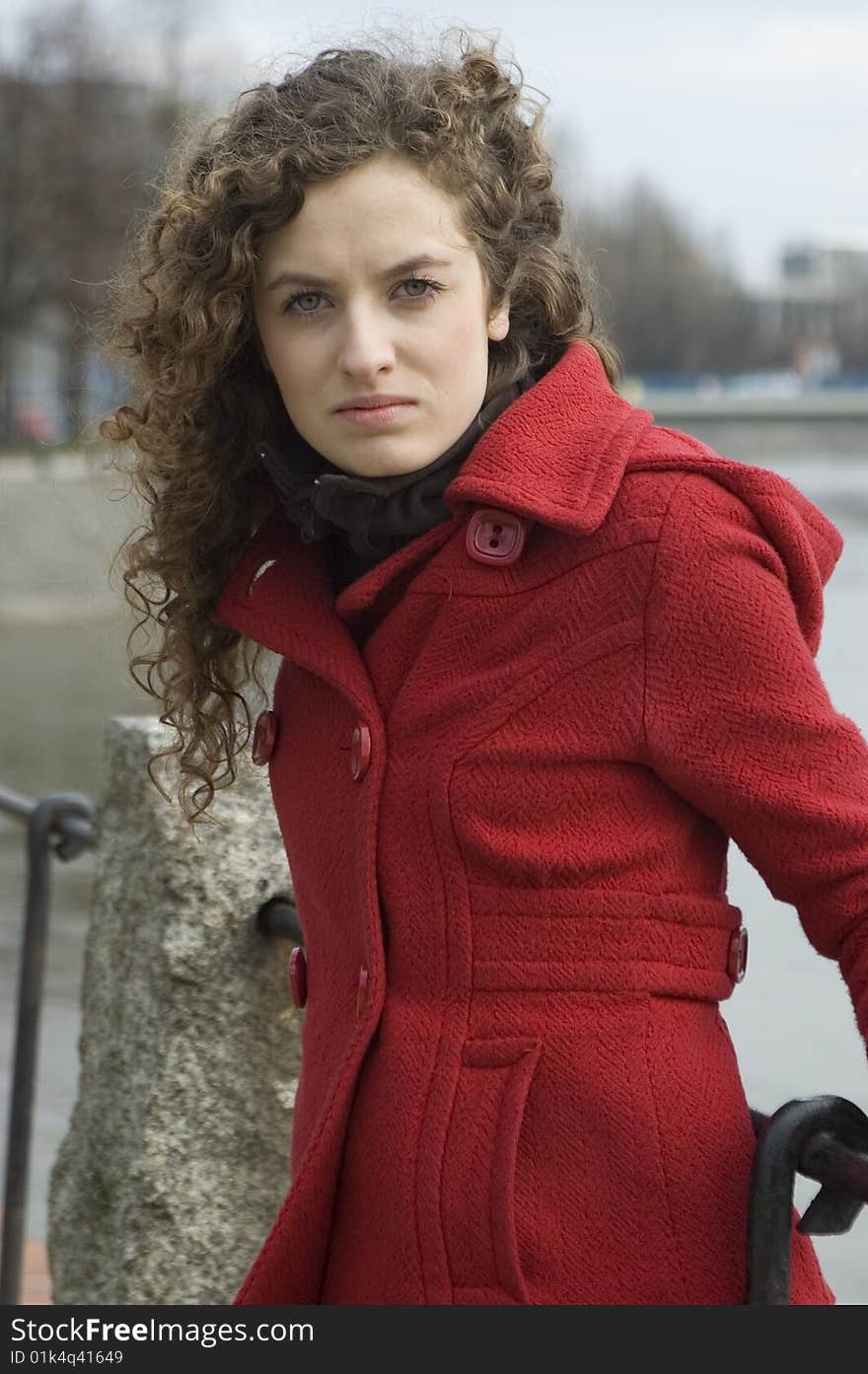 Teenage girl in Poland, portrait. Young girl with curly hairs wearing red coat, posing in Wroclaw city.