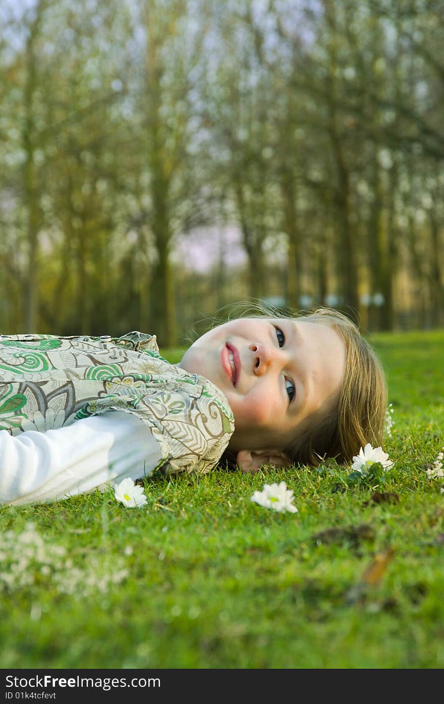 Girl relaxing on grass in park.