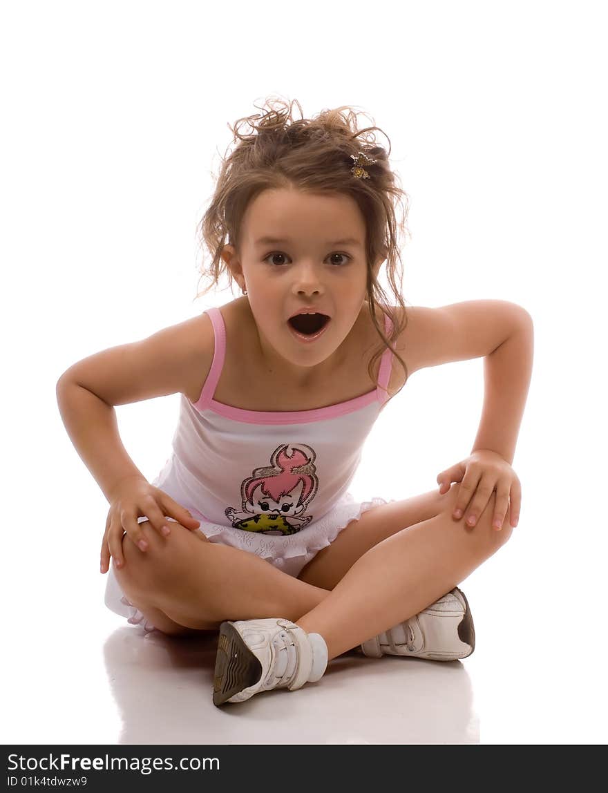 The little girl in a white dress sitting on the floor. The little girl in a white dress sitting on the floor