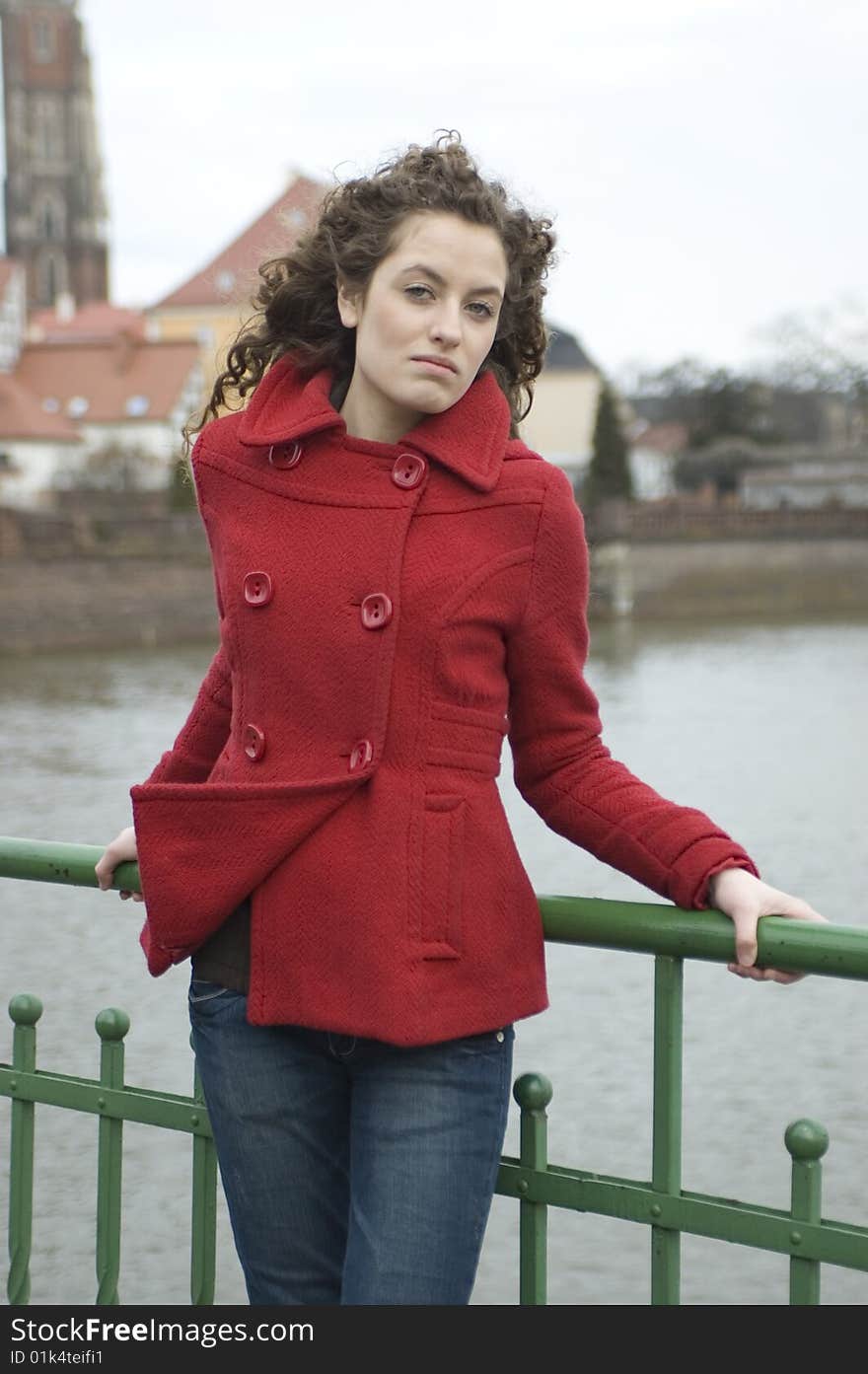 Teenage girl in Poland, portrait. Young girl with curly hairs wearing red coat, posing in Wroclaw city.