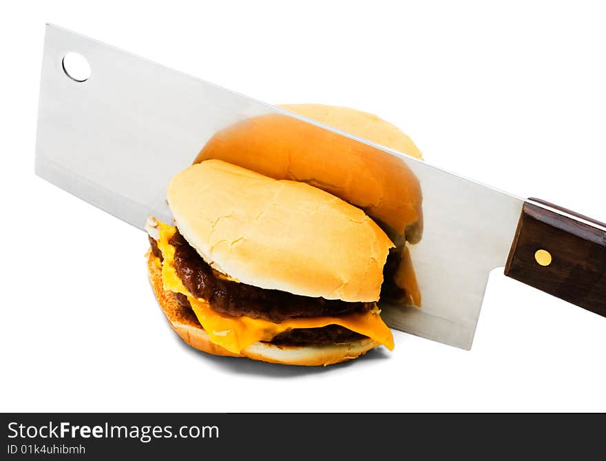 Meat cleaver cutting a burger isolated over white