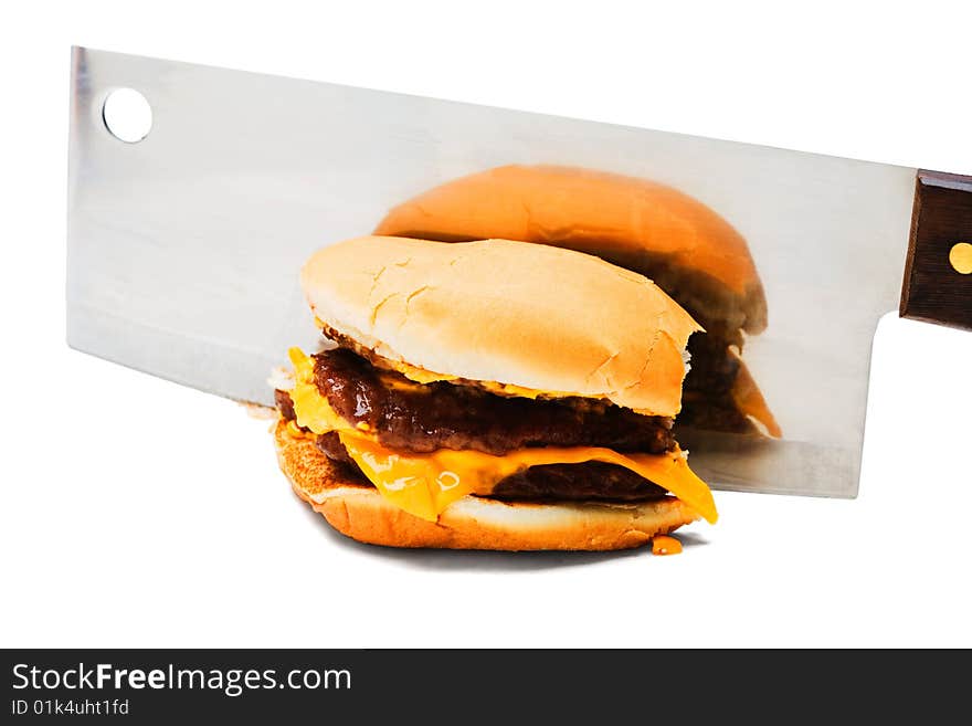 Meat cleaver cutting a burger isolated over white