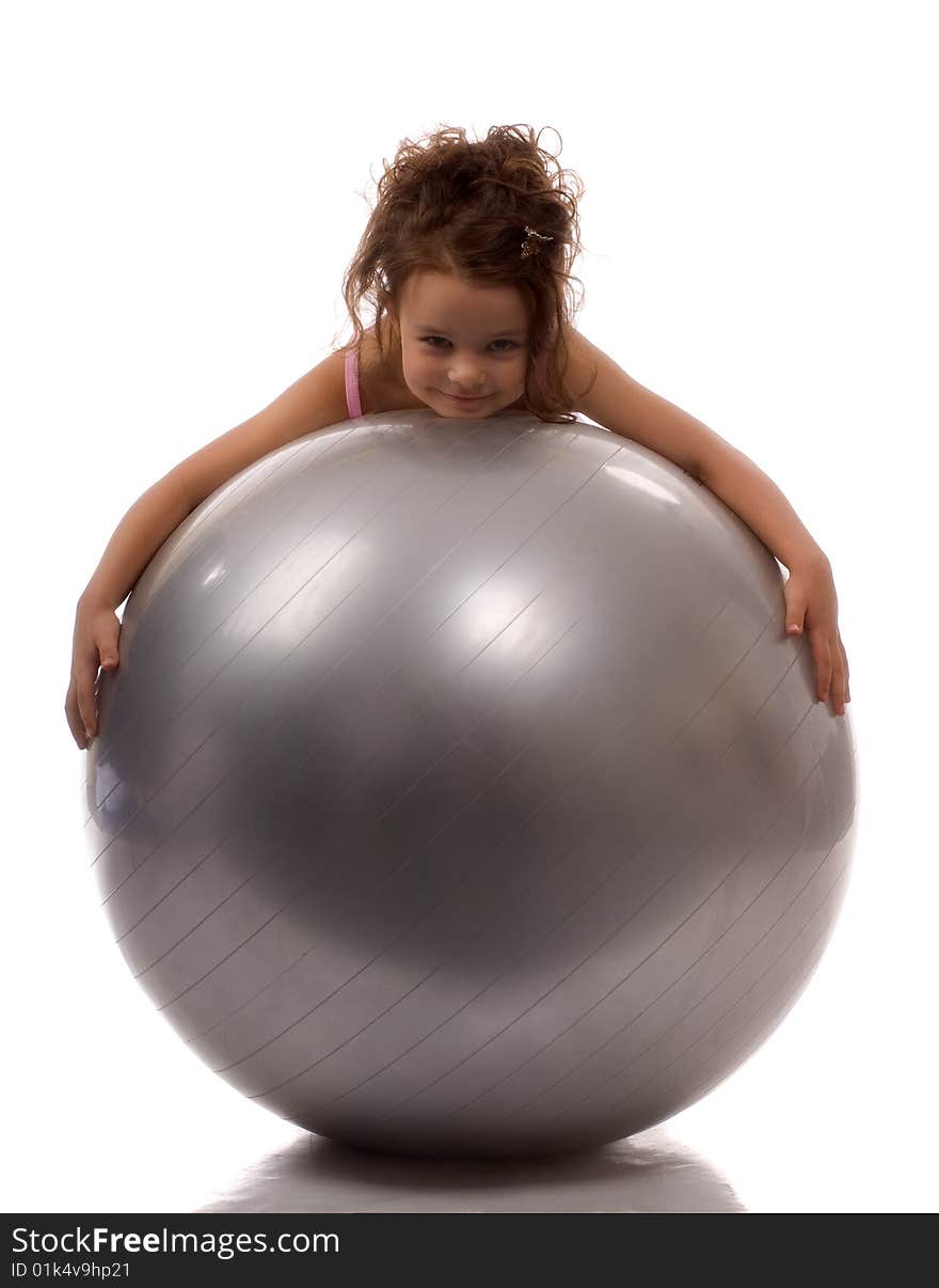 A little girl lying on a big gray ball. A little girl lying on a big gray ball