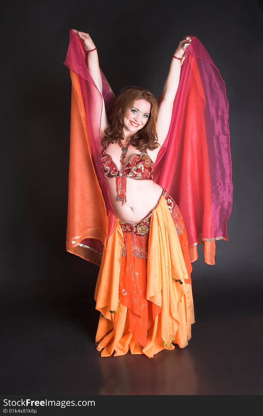 Belly Dancer wearing a red costume with jewelery. Belly Dancer wearing a red costume with jewelery