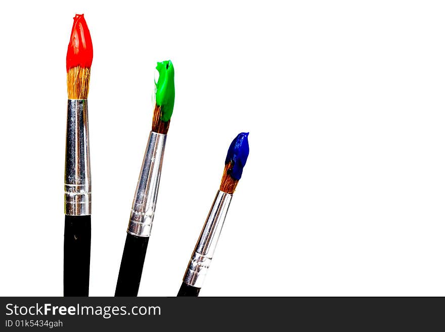 Several paintbrushes with colored paint: red, blue, green, yellow, white and black