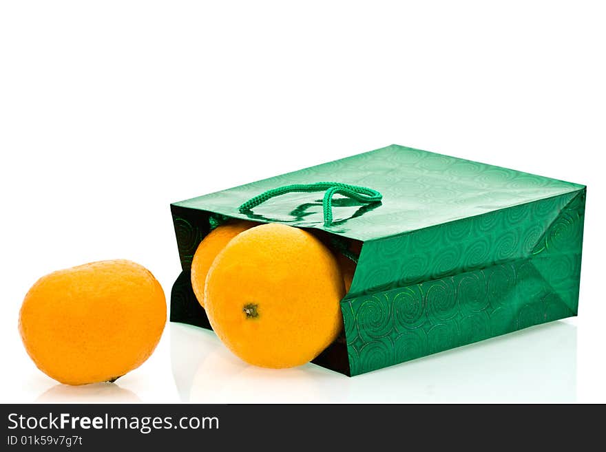 Green package and mandarines on a white background