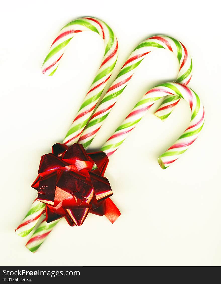 Three candy canes with red bow on white background isolated, Christmas background