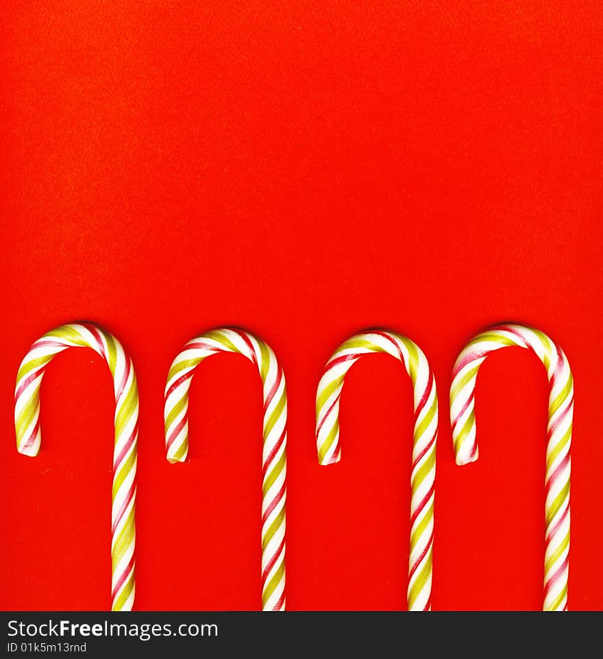 Four red and green Christmas candy canes isolated on red