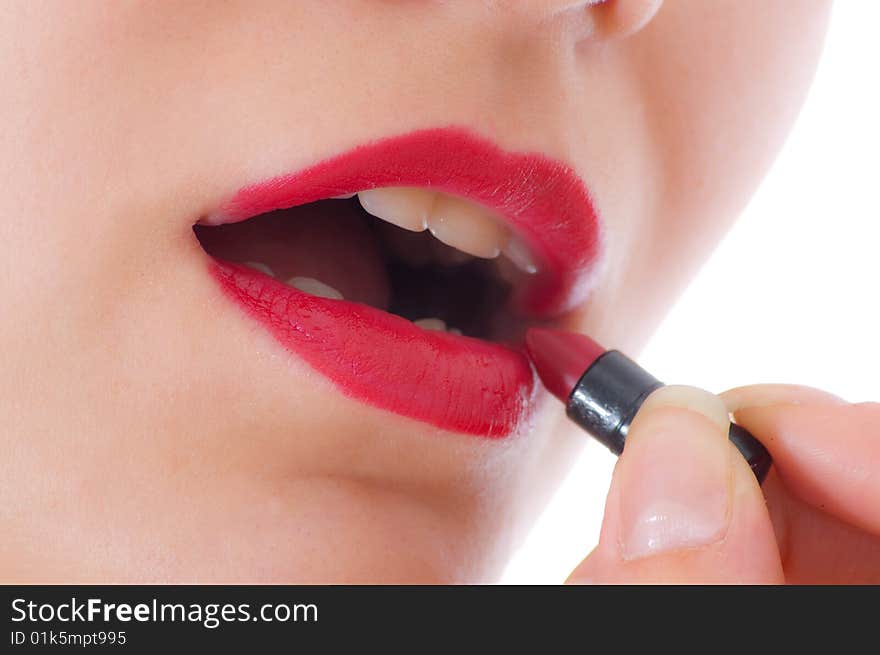 Pretty girl rouging lips by red lipstick