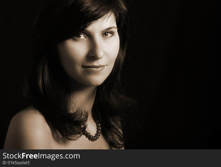 Portrait of young woman on black background