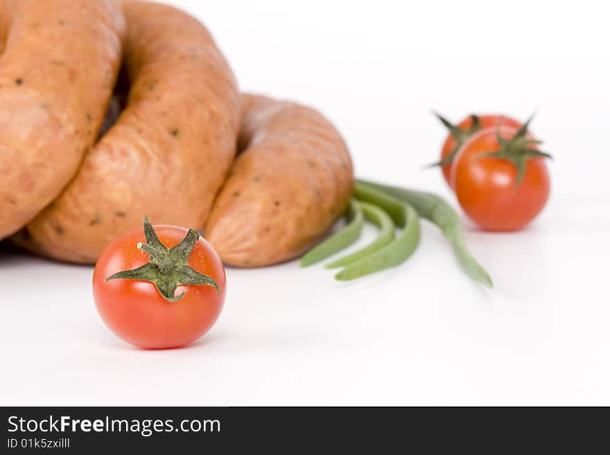 Detail of sausages with tomato on a white background