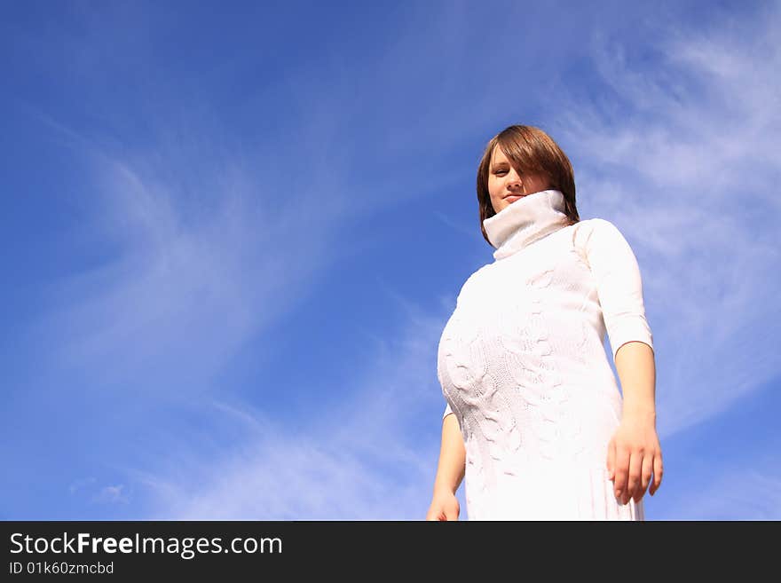 Pregnant happy girl up hands on a background blue sky. Pregnant happy girl up hands on a background blue sky