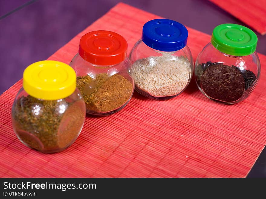 Four glass jars with spices and color covers