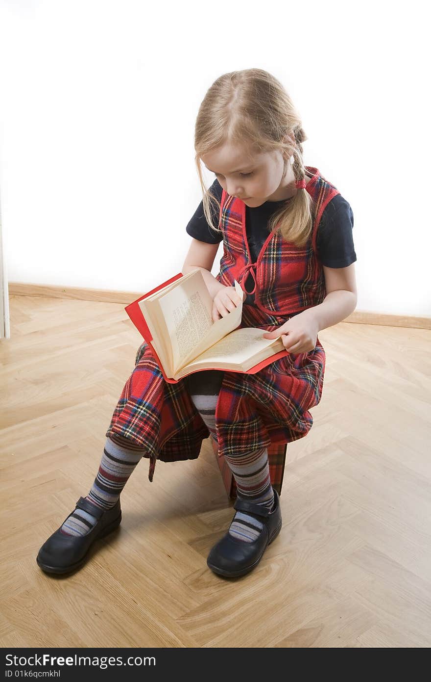 Serious schoolgirl with red book over white. Serious schoolgirl with red book over white