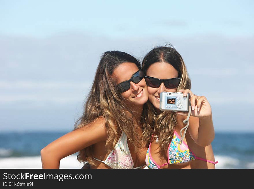 Twins taking a photo of themselves on the beach