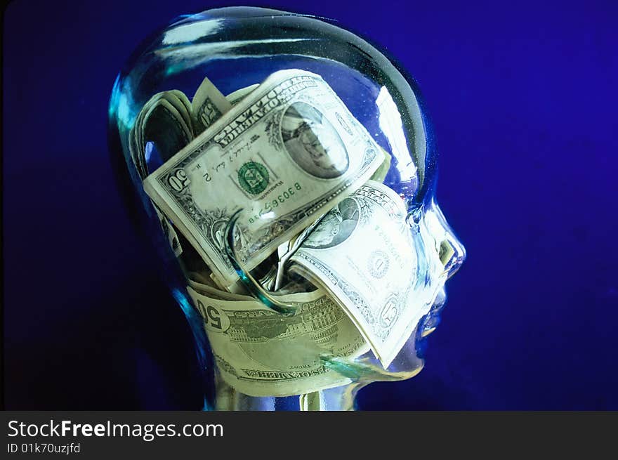 Fifty Dollar Bills in Piles inside of a glass head with a blue back round. Fifty Dollar Bills in Piles inside of a glass head with a blue back round