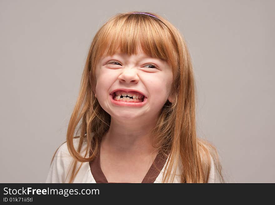 Portrait of an Adorable Red Haired Girl on a Grey Background.