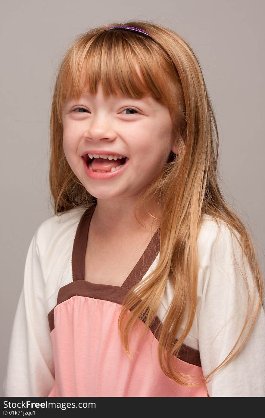 Portrait of an Adorable Red Haired Girl on a Grey Background.