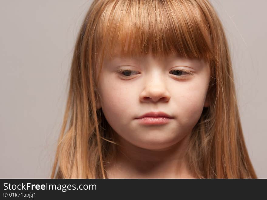 Portrait of an Adorable Red Haired Girl on a Grey Background.