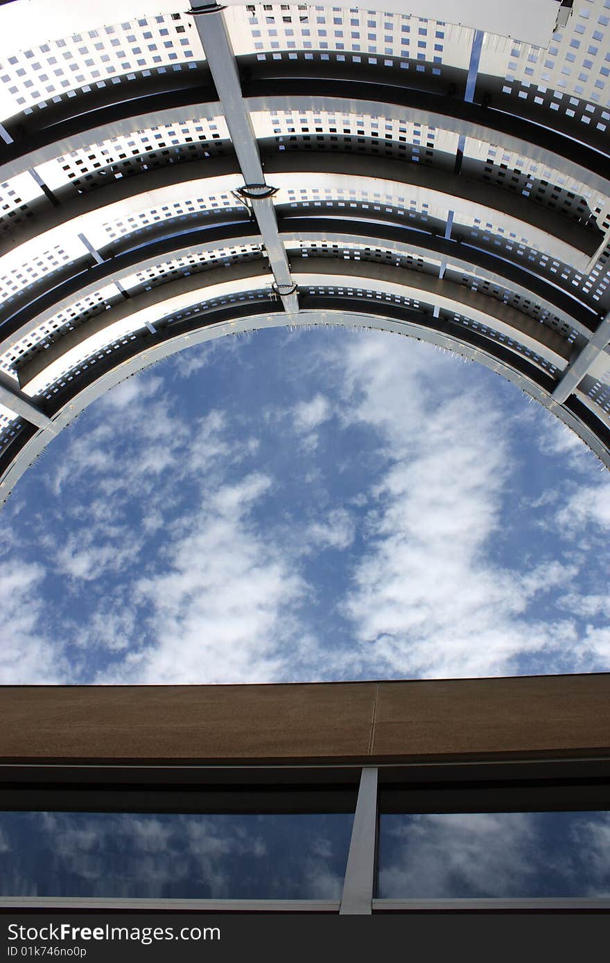 An outdoor patio with no roof, perfectly framing a partially cloudy sky. An outdoor patio with no roof, perfectly framing a partially cloudy sky