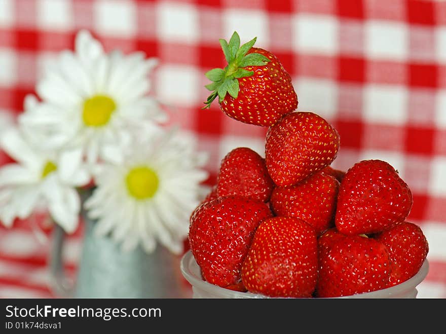 Bowl of fresh strawberries with daisy bouquet. Bowl of fresh strawberries with daisy bouquet.